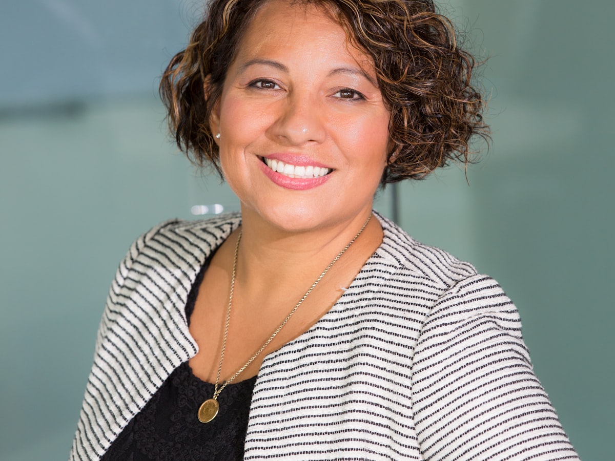 A business portrait of a presenter against a plain background.