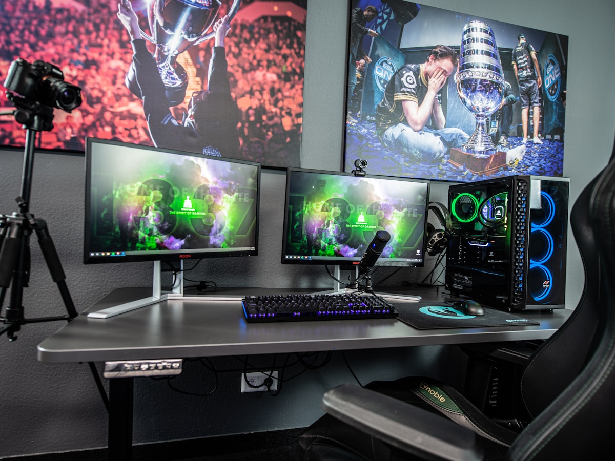A multi-monitor editing rig with colourful graphics on screen.